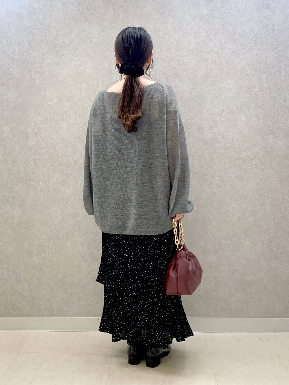 グレー系のニット/セーター、グレー系のスカート、ブラック系のローファーを着用したレディースの秋コーディネートの3枚目の写真