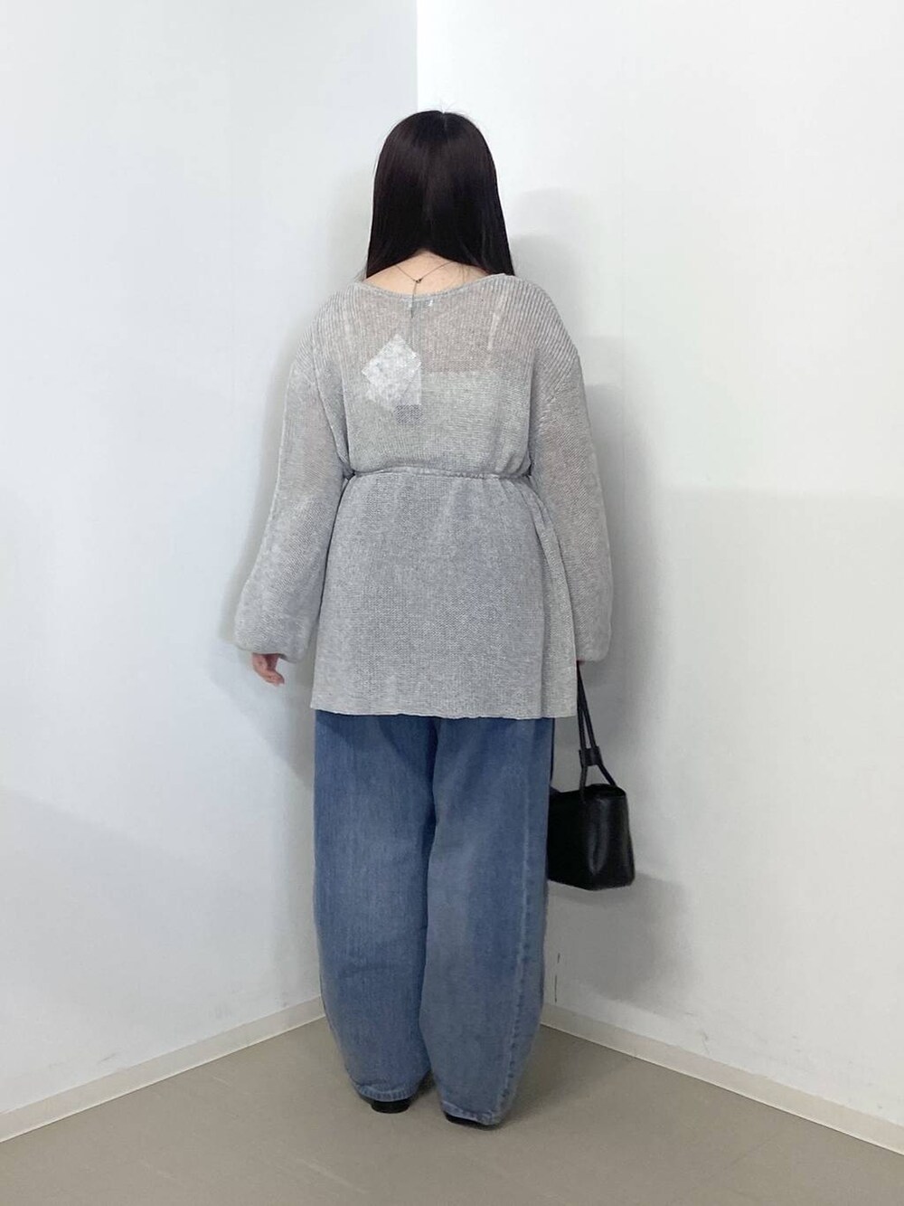 ブルー系のデニムパンツ、ブラック系のショルダーバッグ、ブラック系のパンプスを着用したレディースの春コーディネートの3枚目の写真