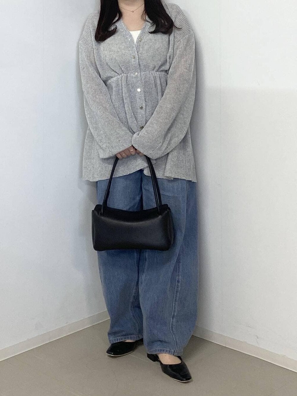 ブルー系のデニムパンツ、ブラック系のショルダーバッグ、ブラック系のパンプスを着用したレディースの春コーディネートの4枚目の写真