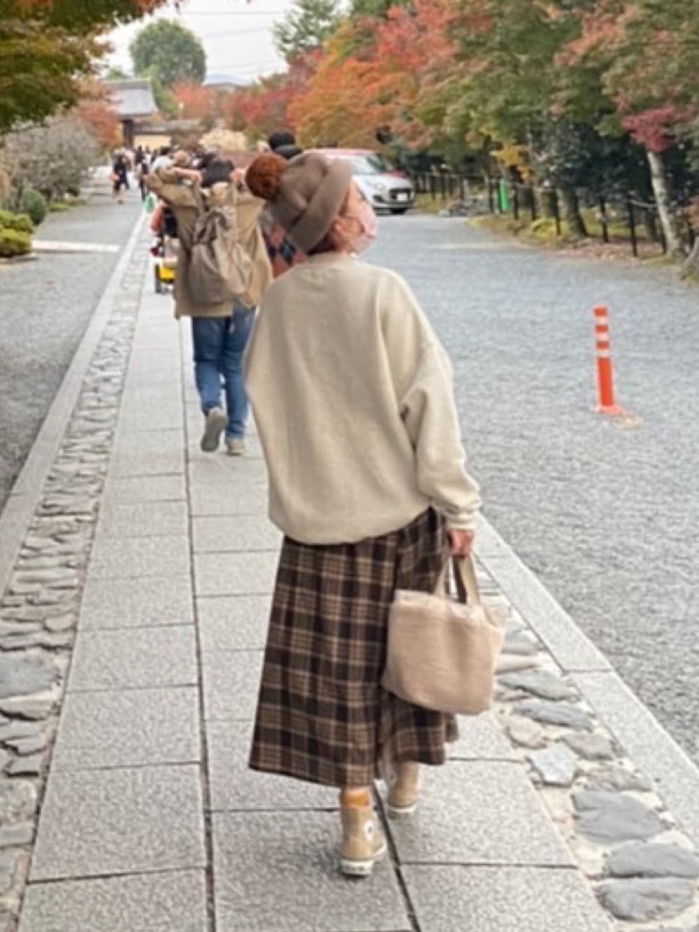 ベージュ系のスウェット、ホワイト系のトートバッグ、ベージュ系のスニーカーを着用したレディースの秋コーディネートの2枚目の写真