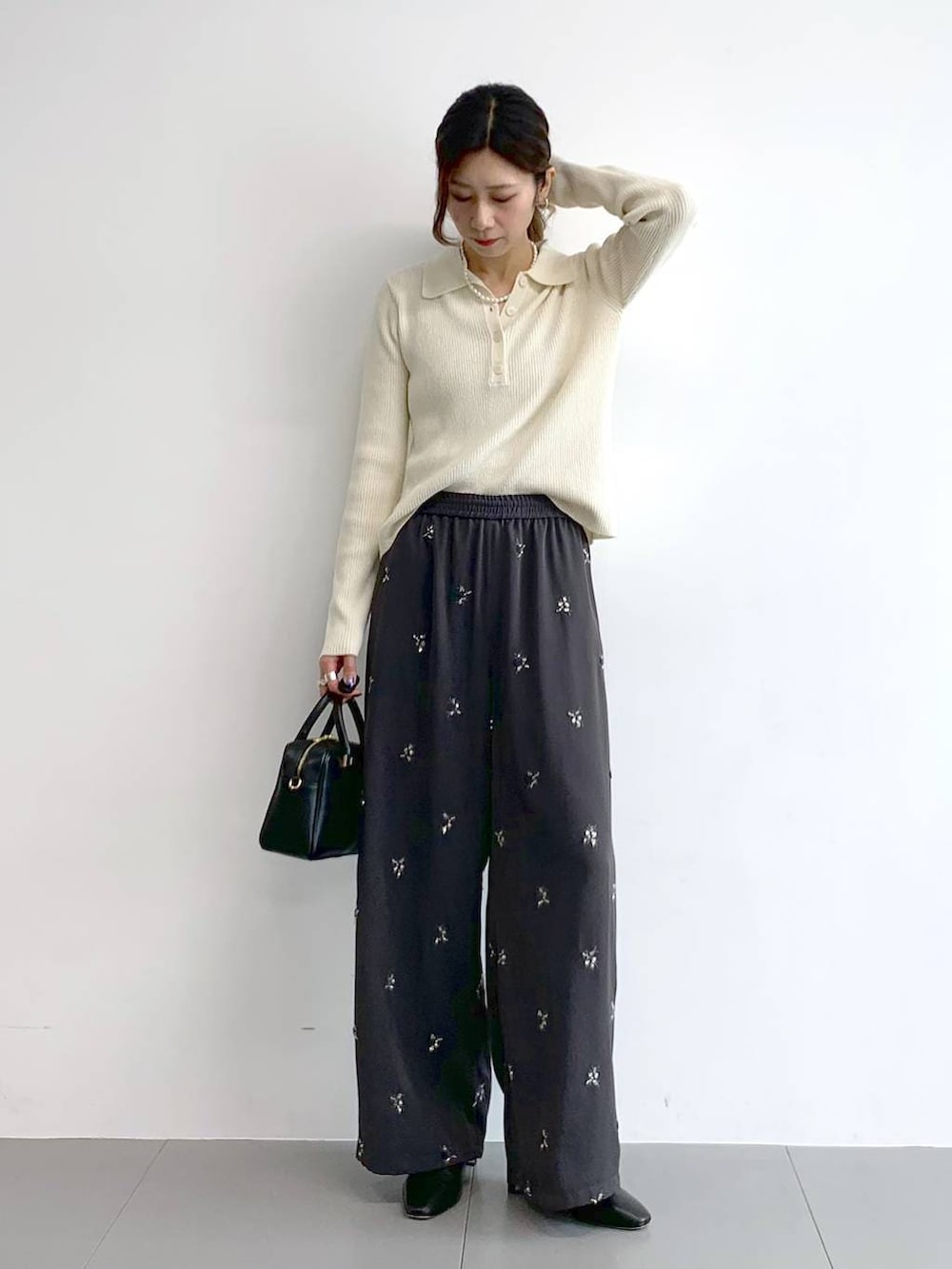 ブラック系のブーツ、ブラック系のボストンバッグ、グレー系のその他パンツを着用したレディースの冬コーディネートの2枚目の写真