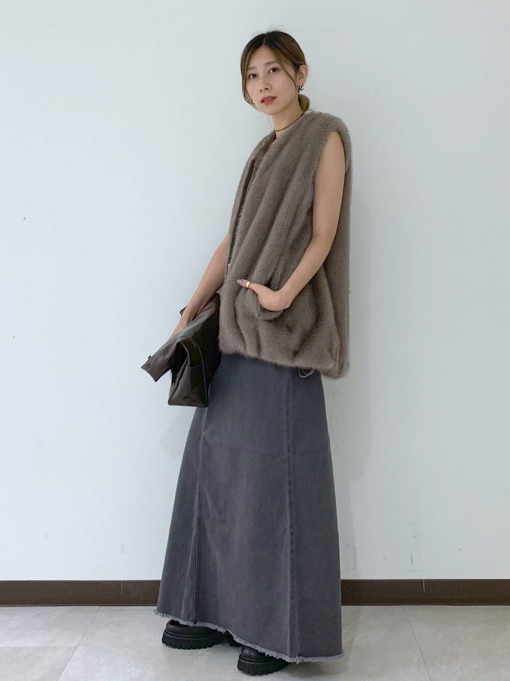 ホワイト系のキャミソール、グレー系のスカート、ブラウン系のその他アウターを着用したレディースの秋コーディネートの5枚目の写真