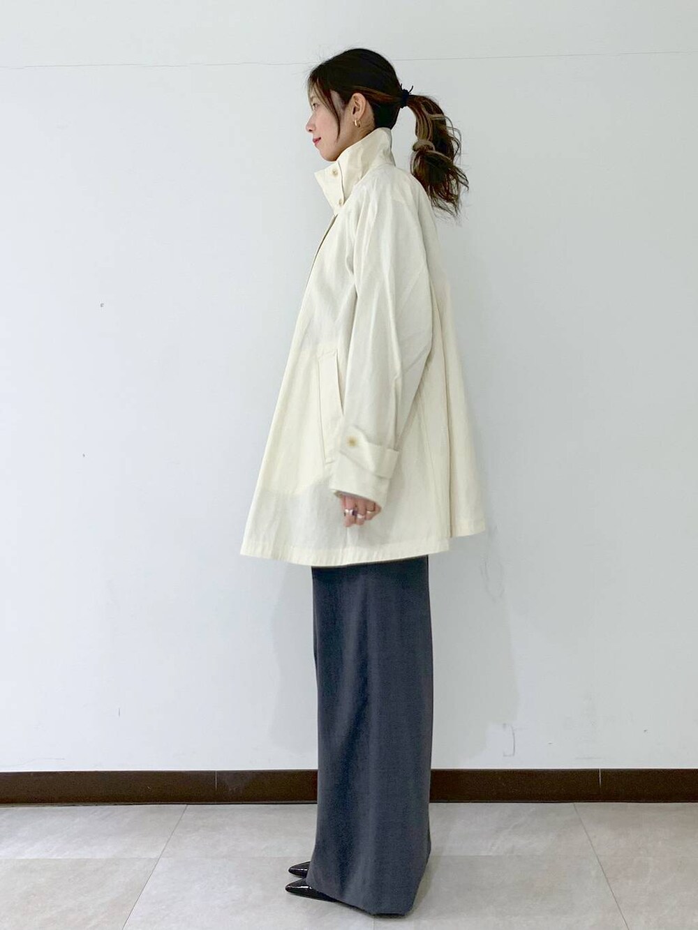 グレー系のその他パンツ、ホワイト系のその他アウター、グレー系のニット/セーターを着用したレディースの春コーディネートの3枚目の写真