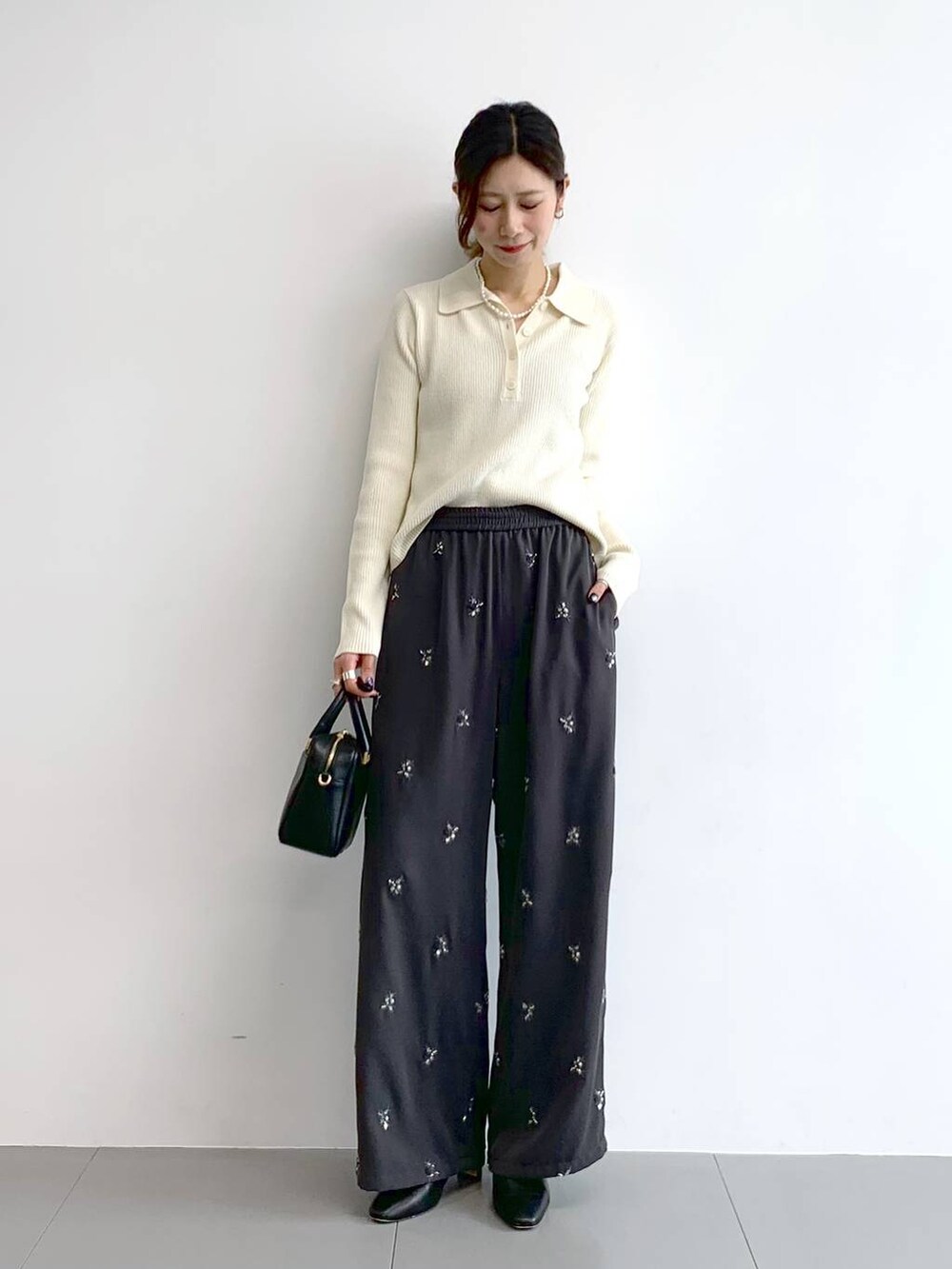 ブラック系のブーツ、ブラック系のボストンバッグ、グレー系のその他パンツを着用したレディースの冬コーディネートの6枚目の写真