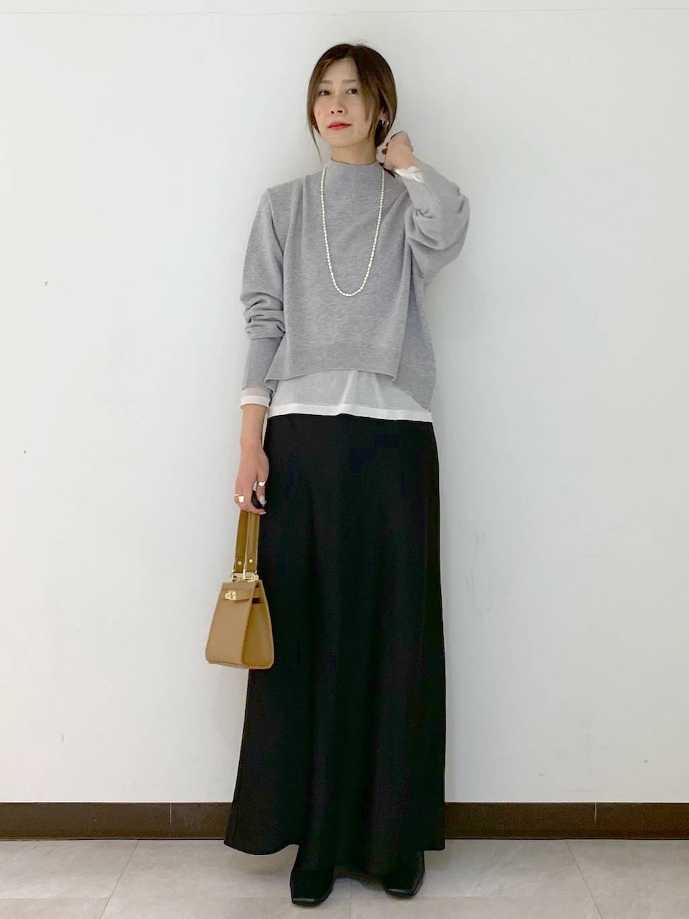 ホワイト系のTシャツ/カットソー、イエロー系のショルダーバッグ、ブラック系のスカートを着用したレディースの冬コーディネートの2枚目の写真