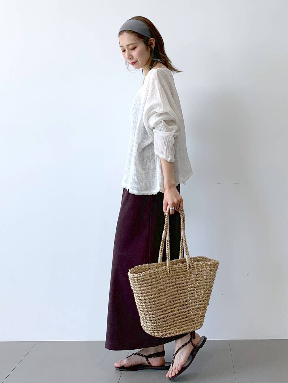 ベージュ系のかごバッグ、ブラウン系のサンダル、ブラウン系のワンピースを着用したレディースの夏コーディネートの8枚目の写真