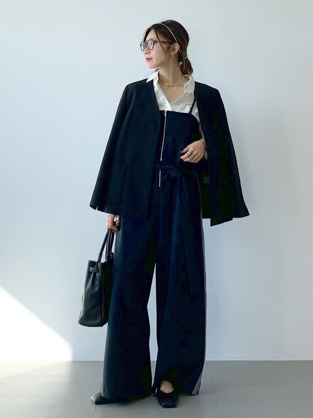 ブラック系のノーカラージャケット、ホワイト系のシャツ/ブラウス、ブラック系のつなぎ/オールインワンを着用したレディースの春コーディネートの7枚目の写真