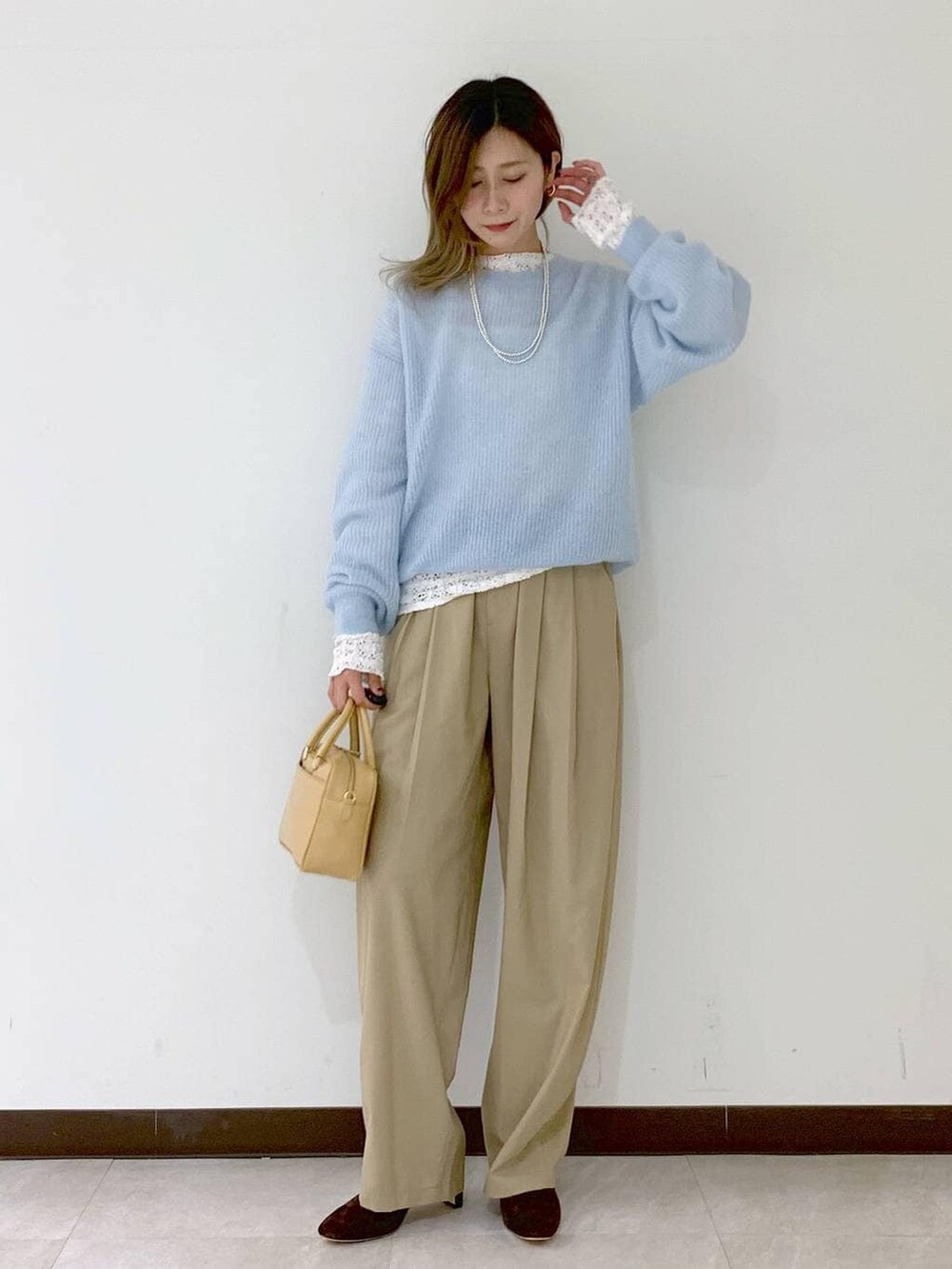 ベージュ系のショルダーバッグ、ベージュ系のその他パンツ、ホワイト系のTシャツ/カットソーを着用したレディースの冬コーディネートの7枚目の写真