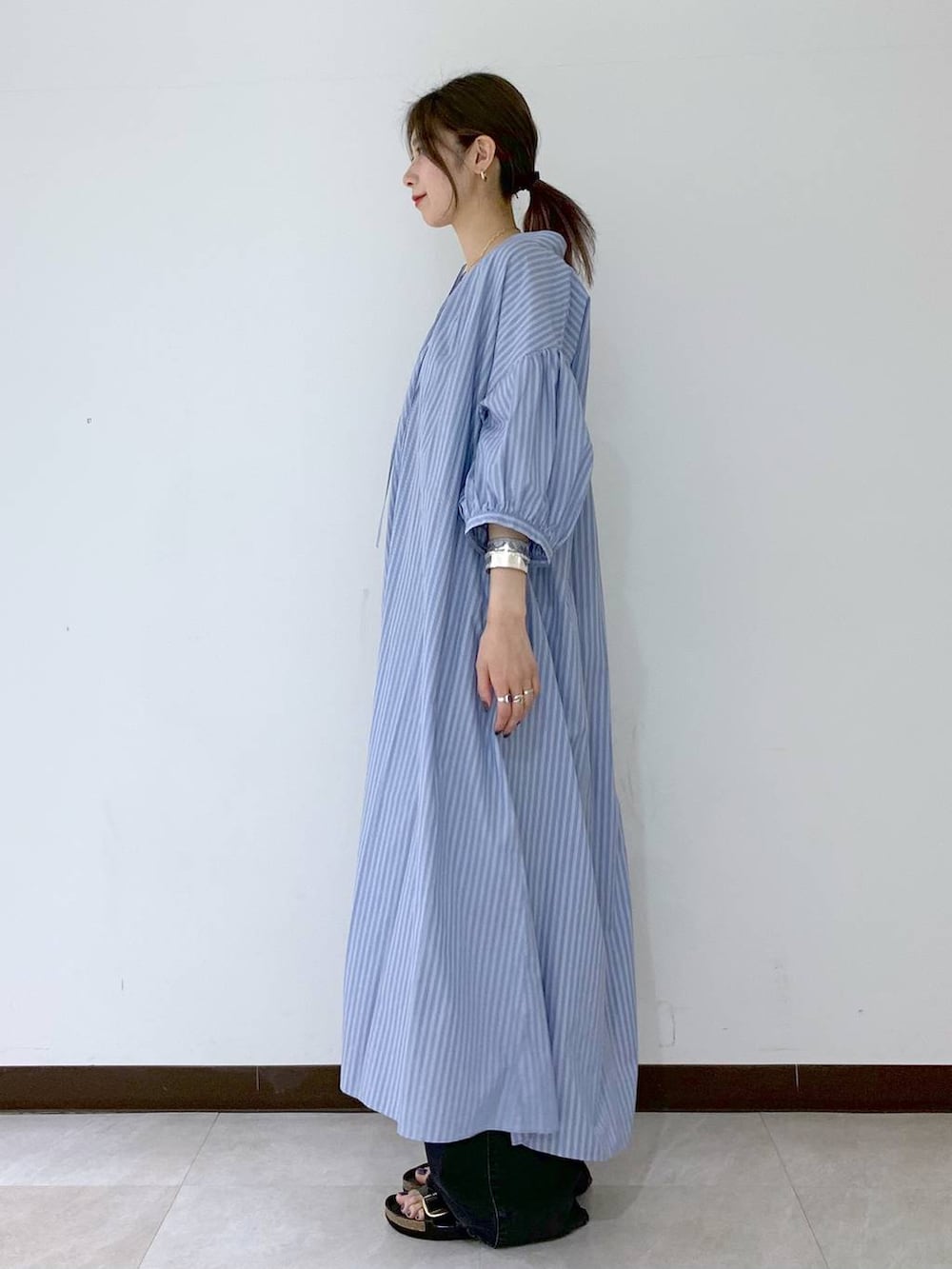 ブラック系のサンダル、ブラック系のデニムパンツ、ブルー系のワンピースを着用したレディースの夏コーディネートの3枚目の写真