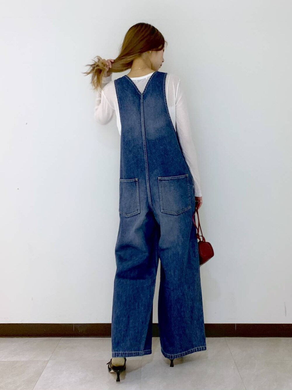 レッド系のショルダーバッグ、ホワイト系のTシャツ/カットソー、ブラウン系のソックス/靴下を着用したレディースの秋コーディネートの4枚目の写真