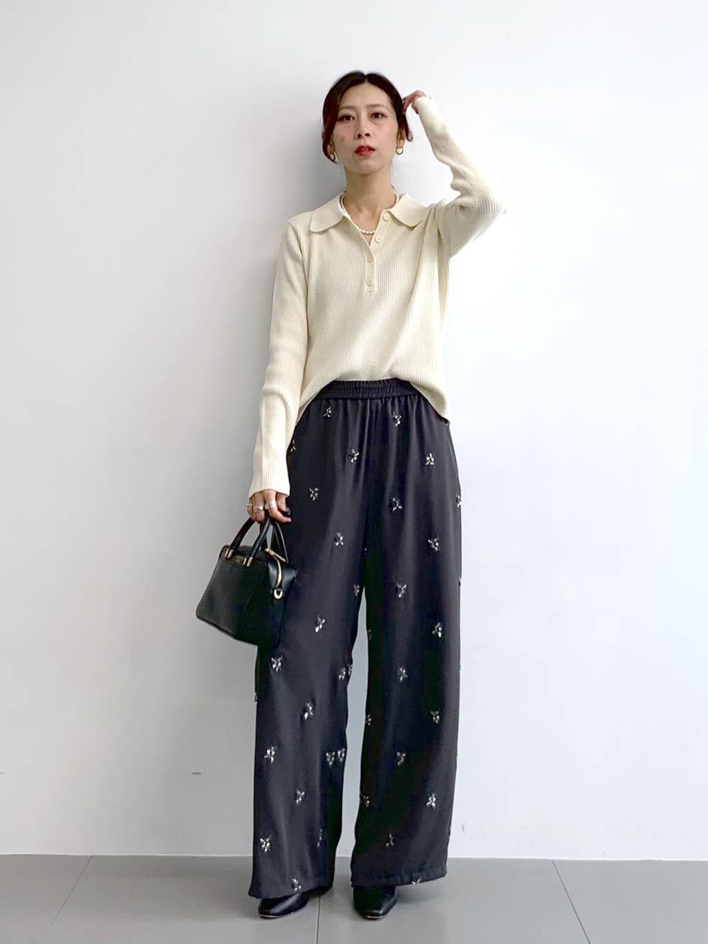 ブラック系のブーツ、ブラック系のボストンバッグ、グレー系のその他パンツを着用したレディースの冬コーディネートの5枚目の写真