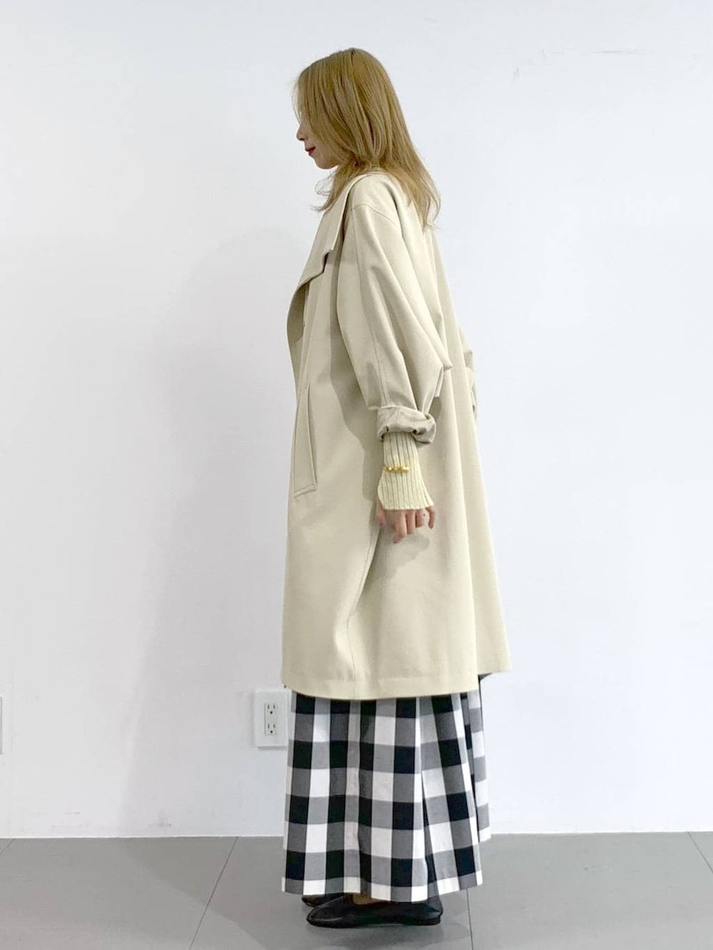 イエロー系のニット/セーター、ベージュ系のその他アウター、ブラック系のスカートを着用したレディースの冬コーディネートの3枚目の写真