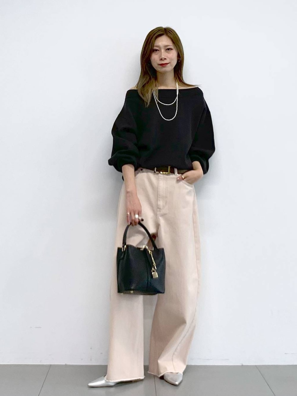 ピンク系のデニムパンツ、シルバー系のパンプス、グレー系のニット/セーターを着用したレディースの冬コーディネートの6枚目の写真