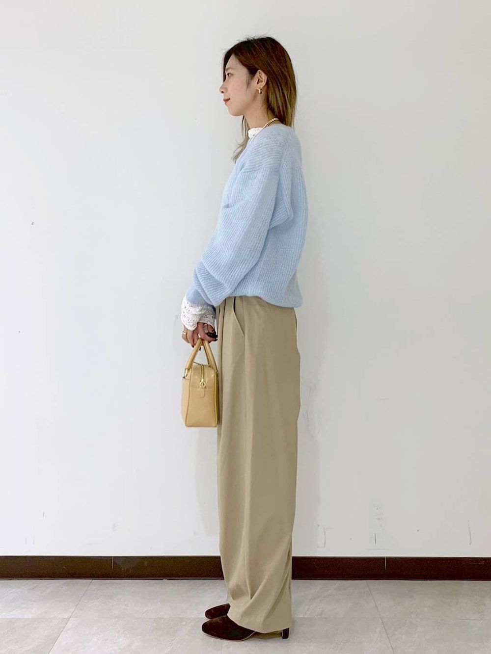 ベージュ系のショルダーバッグ、ベージュ系のその他パンツ、ホワイト系のTシャツ/カットソーを着用したレディースの冬コーディネートの3枚目の写真