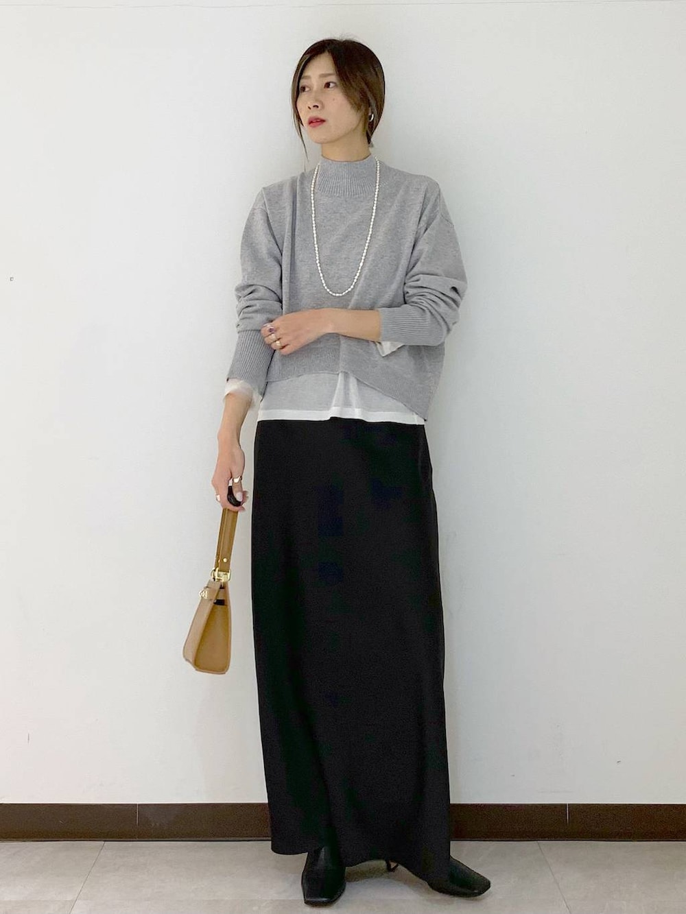 ホワイト系のTシャツ/カットソー、イエロー系のショルダーバッグ、ブラック系のスカートを着用したレディースの冬コーディネートの7枚目の写真