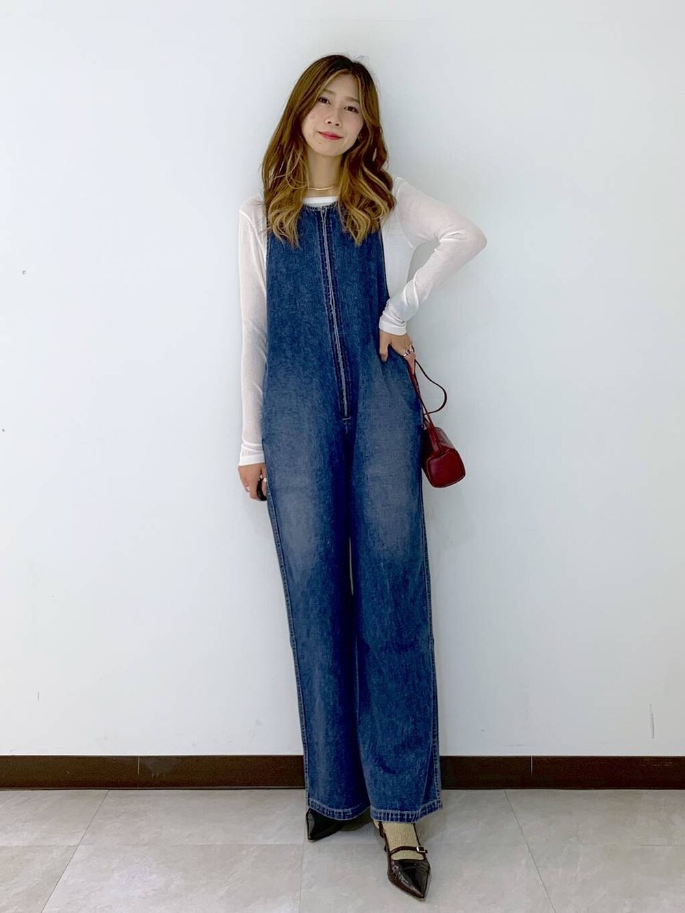 レッド系のショルダーバッグ、ホワイト系のTシャツ/カットソー、ブラウン系のソックス/靴下を着用したレディースの秋コーディネートの5枚目の写真