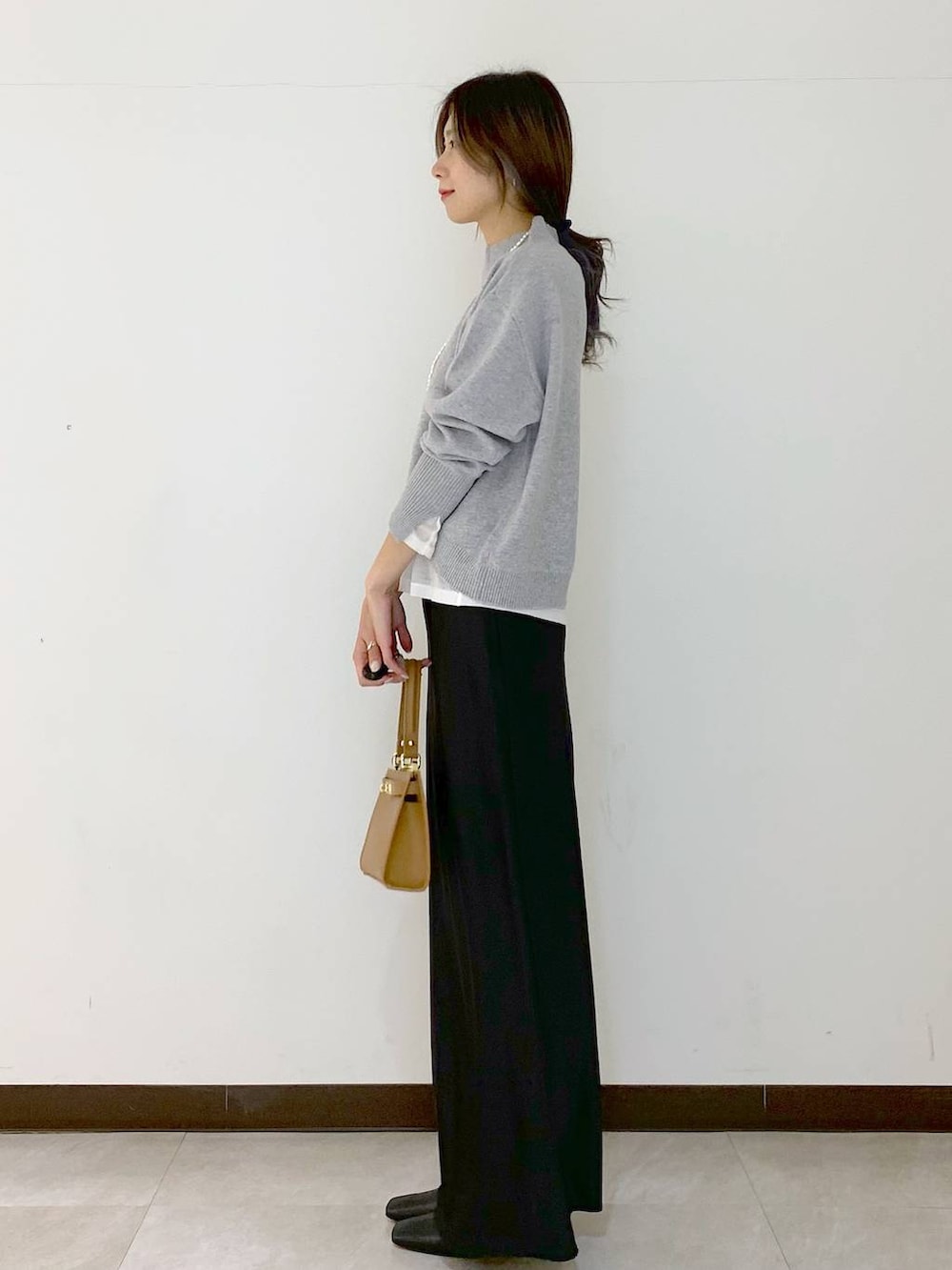 ホワイト系のTシャツ/カットソー、イエロー系のショルダーバッグ、ブラック系のスカートを着用したレディースの冬コーディネートの5枚目の写真