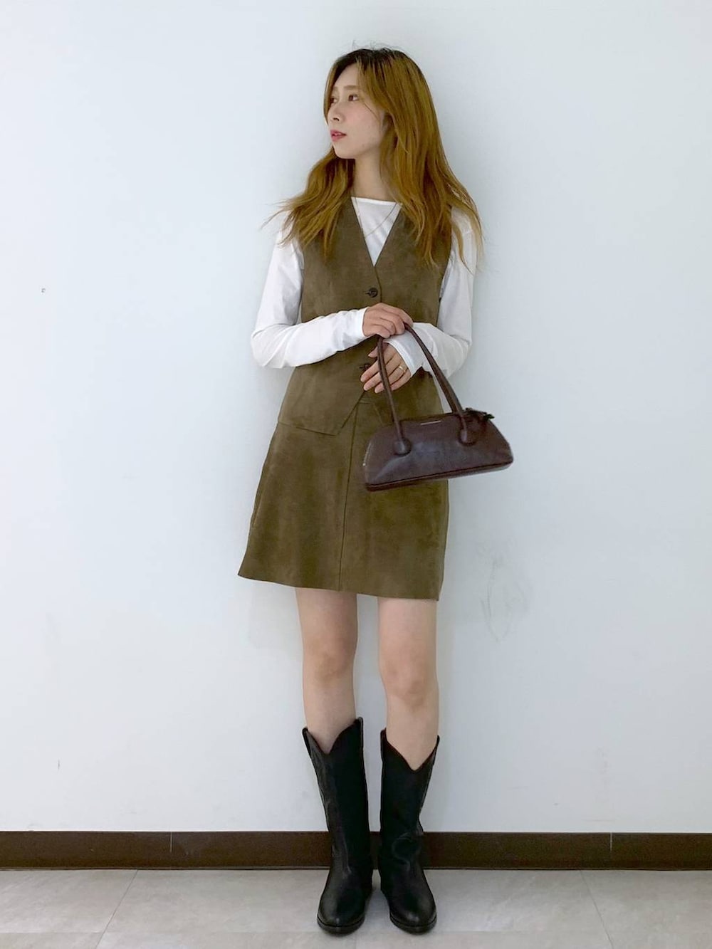 ホワイト系のTシャツ/カットソー、ブラウン系のショルダーバッグ、ベージュ系のベストを着用したレディースの秋コーディネートの5枚目の写真