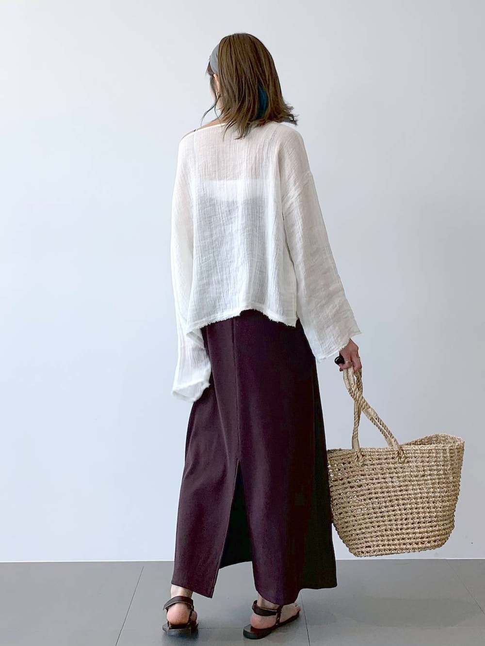 ベージュ系のかごバッグ、ブラウン系のサンダル、ブラウン系のワンピースを着用したレディースの夏コーディネートの5枚目の写真