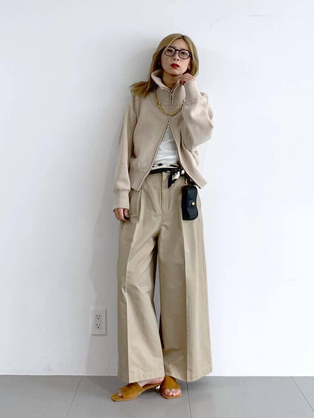 ベージュ系のチノパンツ、ベージュ系のスウェット、ブラウン系のネックレスを着用したレディースの冬コーディネートの4枚目の写真