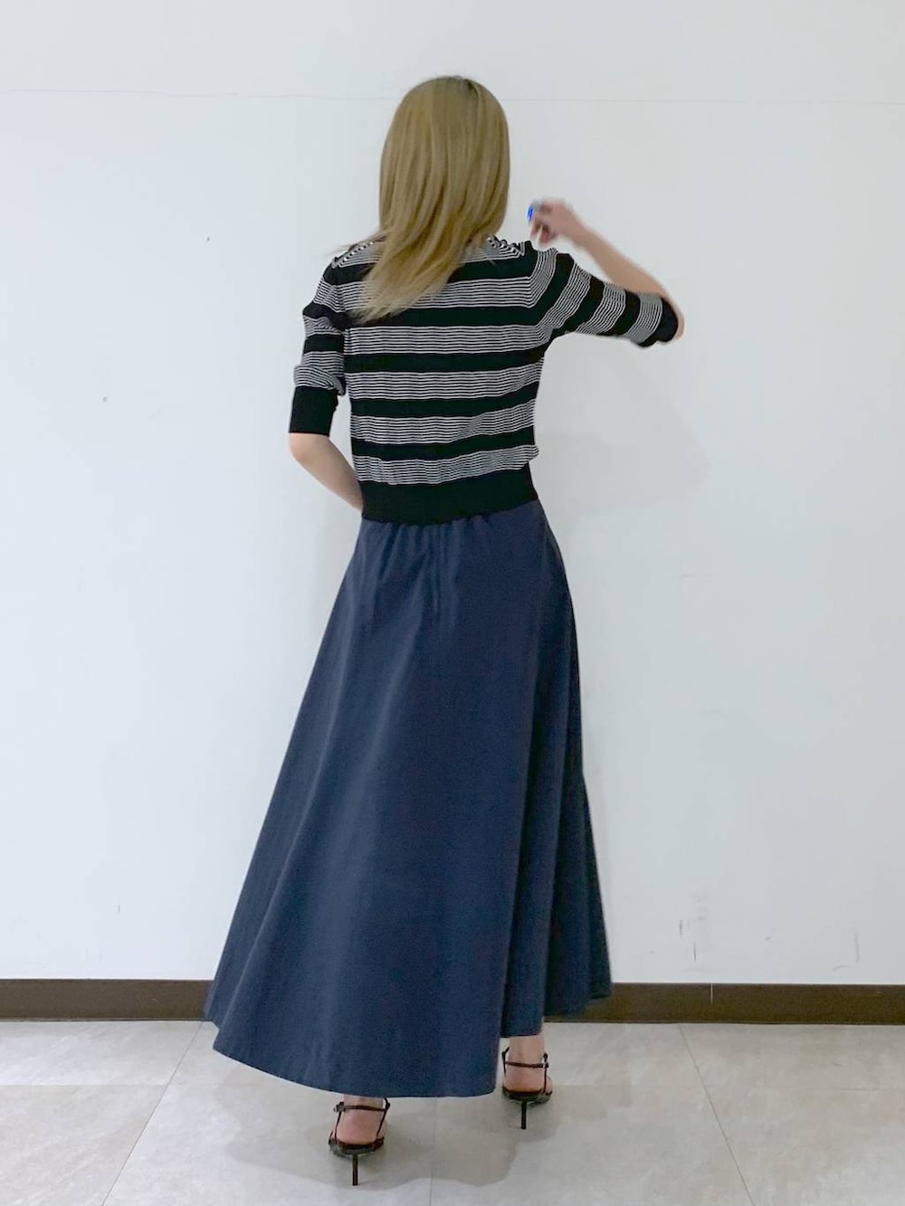 ブラック系のサンダル、ブラック系のハンドバッグ、ブラック系のポロシャツを着用したレディースの春コーディネートの4枚目の写真