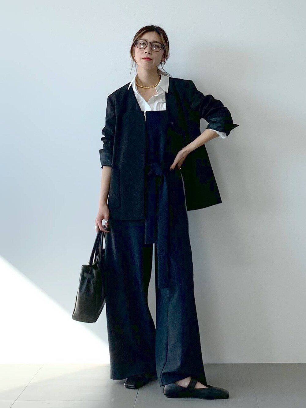 ブラック系のノーカラージャケット、ホワイト系のシャツ/ブラウス、ブラック系のつなぎ/オールインワンを着用したレディースの春コーディネートの4枚目の写真