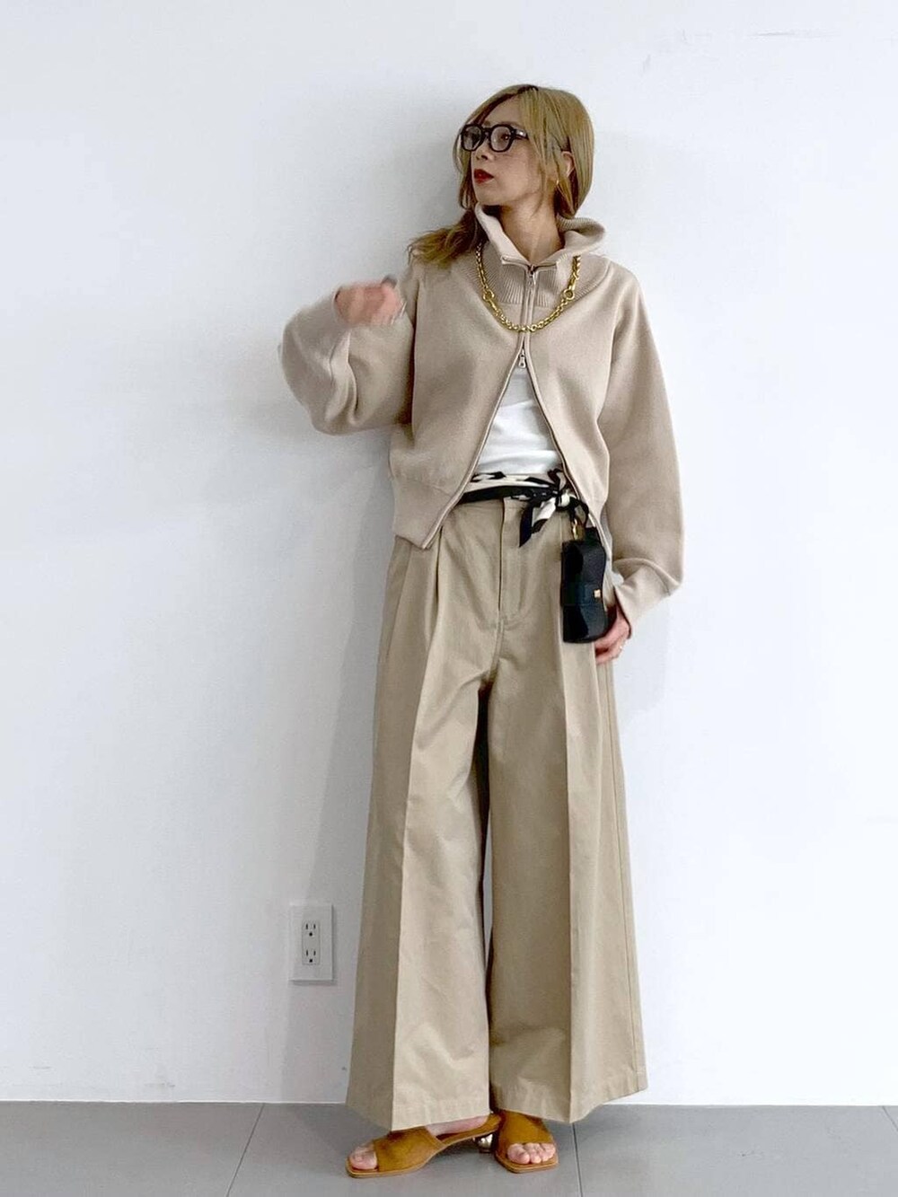 ベージュ系のチノパンツ、ベージュ系のスウェット、ブラウン系のネックレスを着用したレディースの冬コーディネートの5枚目の写真