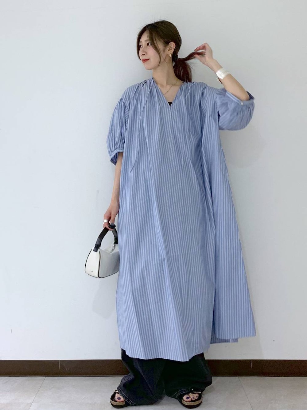 ブラック系のサンダル、ブラック系のデニムパンツ、ブルー系のワンピースを着用したレディースの夏コーディネートの5枚目の写真