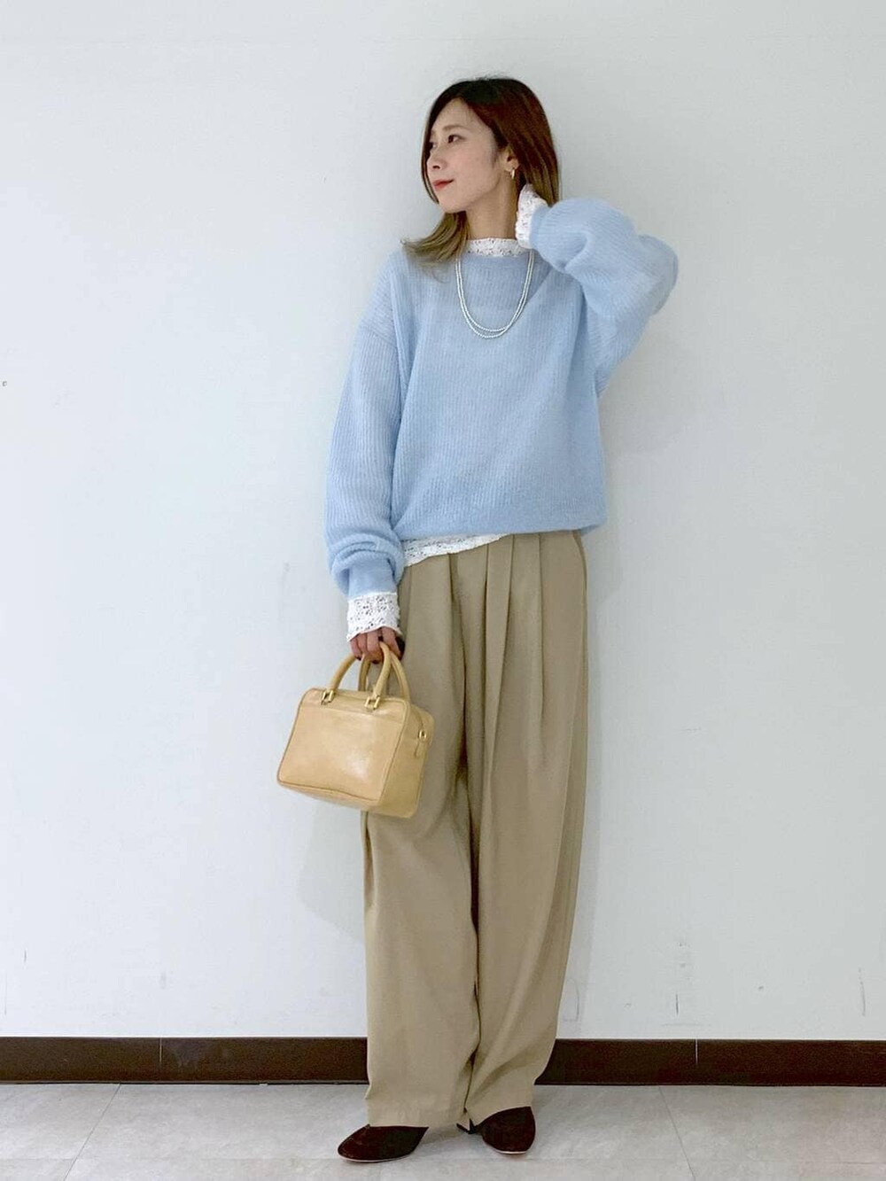 ベージュ系のショルダーバッグ、ベージュ系のその他パンツ、ホワイト系のTシャツ/カットソーを着用したレディースの冬コーディネートの5枚目の写真