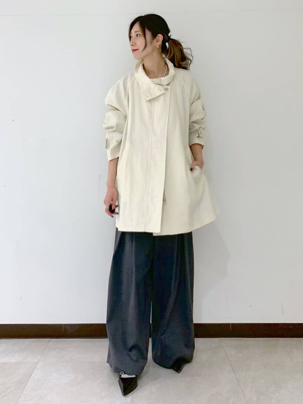 グレー系のその他パンツ、ホワイト系のその他アウター、グレー系のニット/セーターを着用したレディースの春コーディネートの7枚目の写真