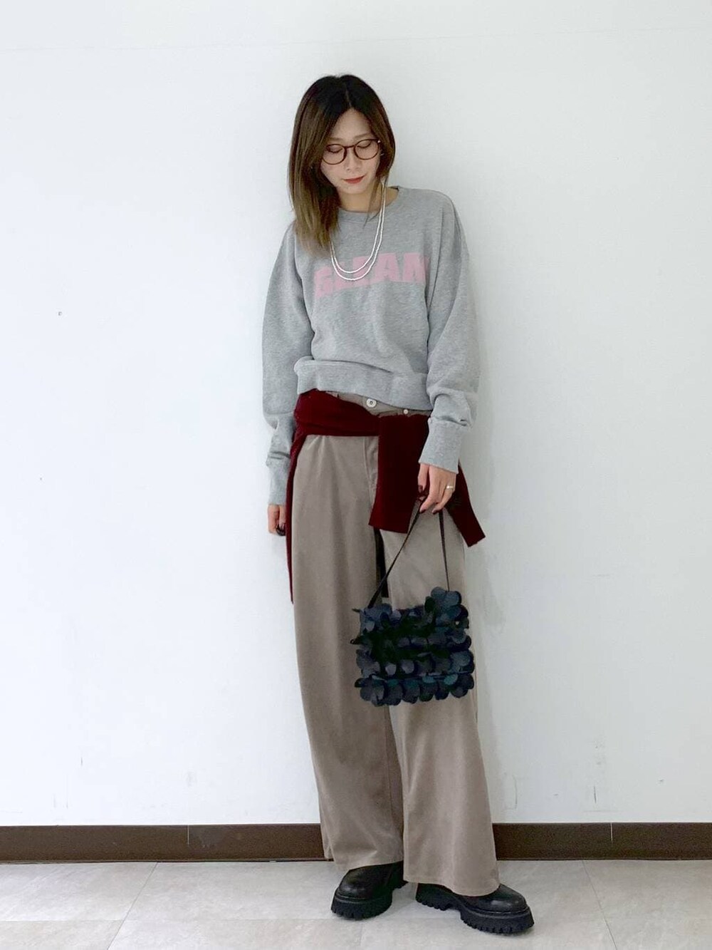 レッド系のカーディガン/ボレロ、ブラック系のショルダーバッグ、ブラック系のサンダルを着用したレディースの冬コーディネートの5枚目の写真