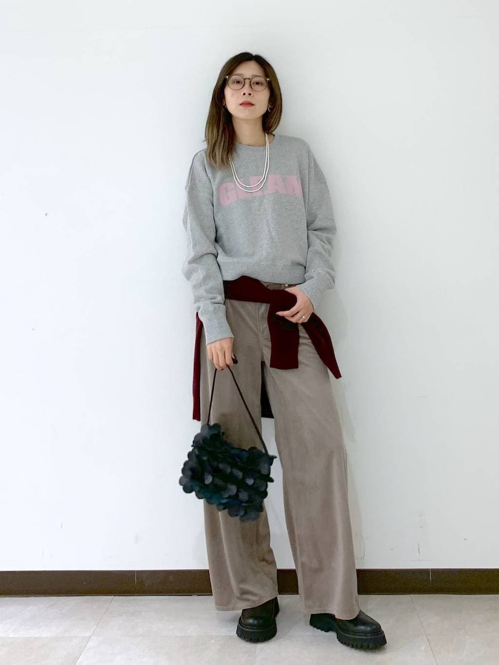 レッド系のカーディガン/ボレロ、ブラック系のショルダーバッグ、ブラック系のサンダルを着用したレディースの冬コーディネートの2枚目の写真