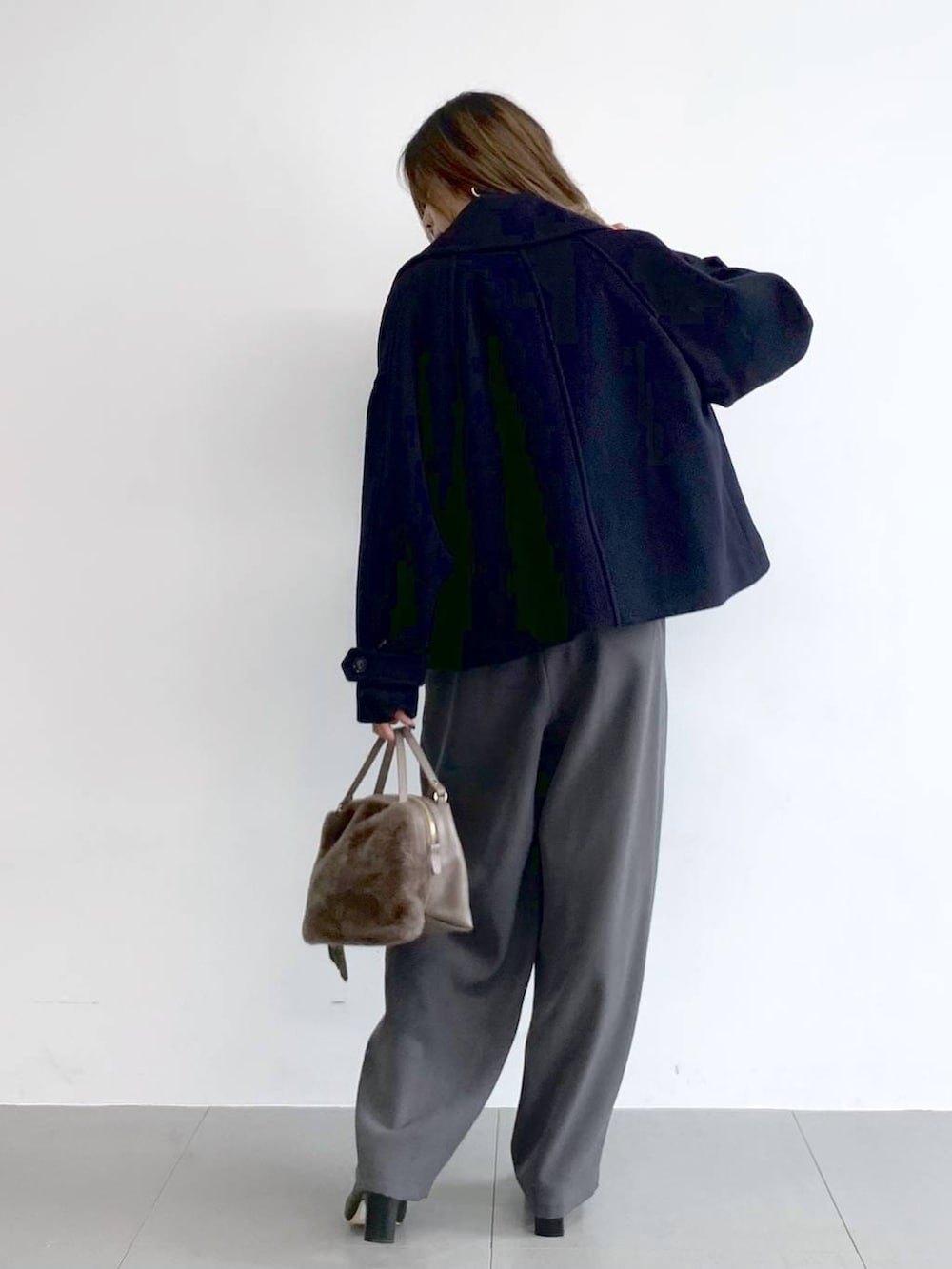 グレー系のその他パンツ、ブラック系のブーツ、ブラウン系のハンドバッグを着用したレディースの冬コーディネートの4枚目の写真