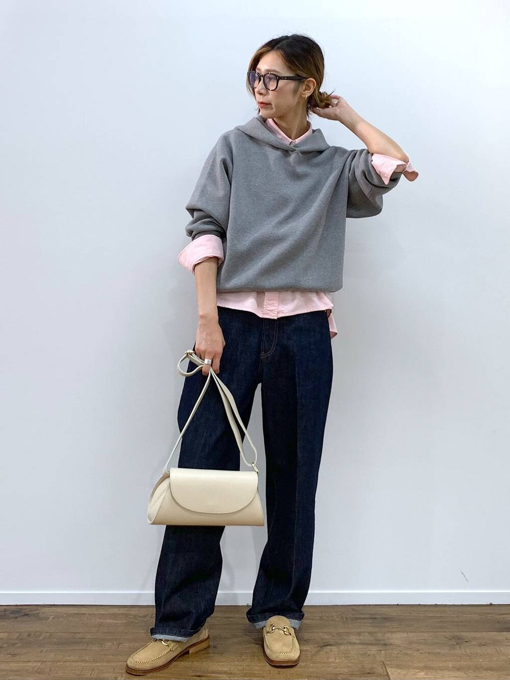 ホワイト系のショルダーバッグ、ピンク系のシャツ/ブラウス、ブルー系のデニムパンツを着用したレディースの秋コーディネートの2枚目の写真