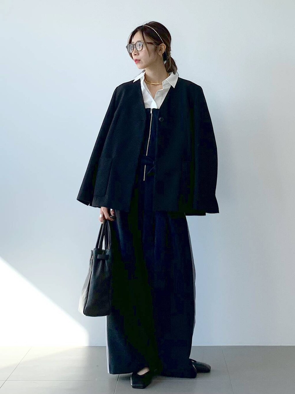 ブラック系のノーカラージャケット、ホワイト系のシャツ/ブラウス、ブラック系のつなぎ/オールインワンを着用したレディースの春コーディネートの6枚目の写真