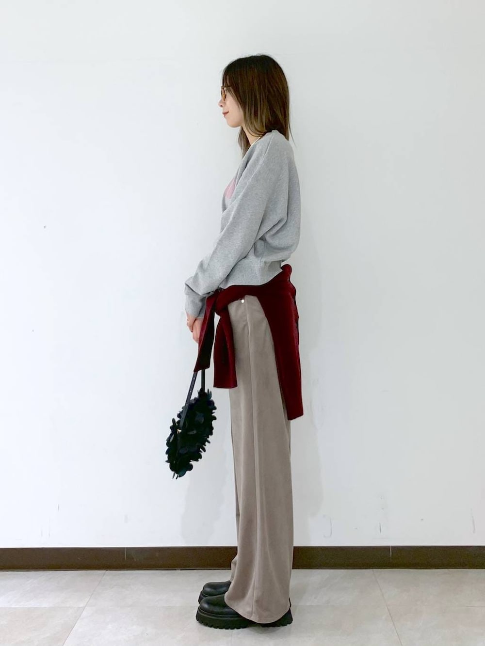 レッド系のカーディガン/ボレロ、ブラック系のショルダーバッグ、ブラック系のサンダルを着用したレディースの冬コーディネートの3枚目の写真