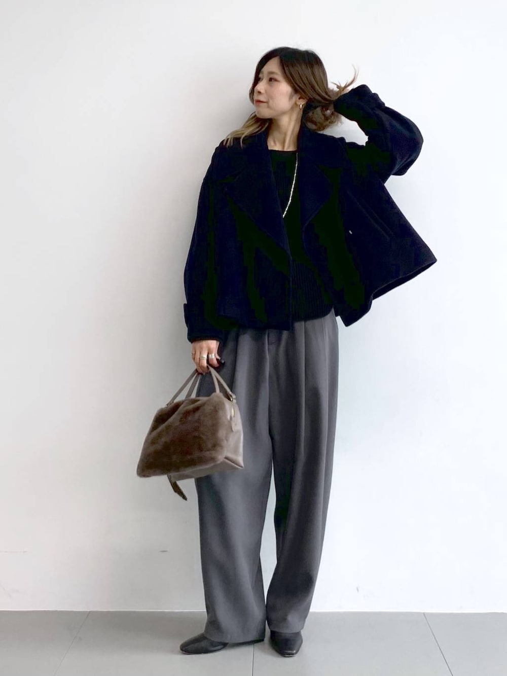 グレー系のその他パンツ、ブラック系のブーツ、ブラウン系のハンドバッグを着用したレディースの冬コーディネートの6枚目の写真