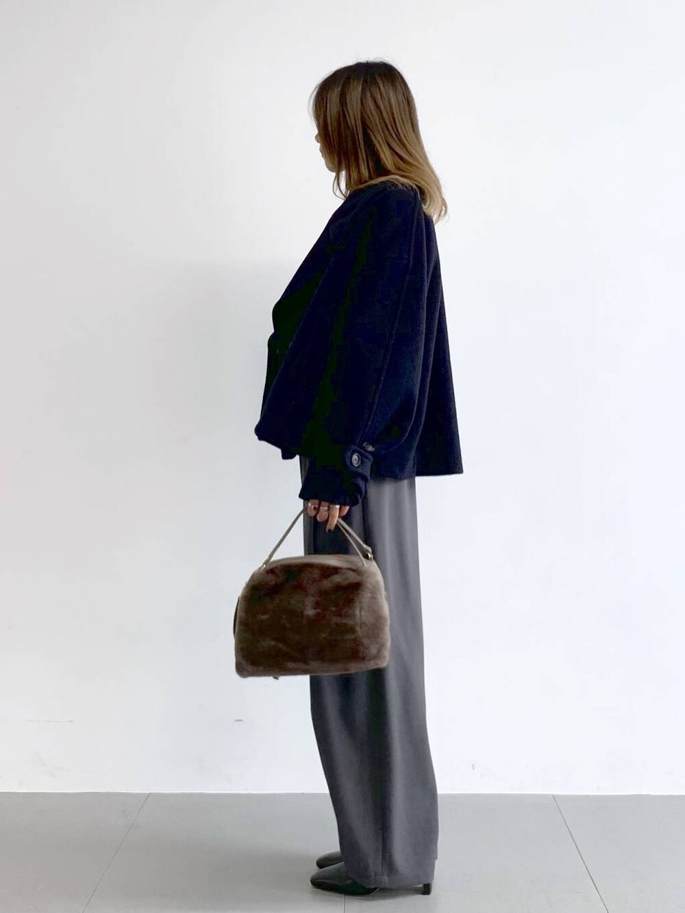 グレー系のその他パンツ、ブラック系のブーツ、ブラウン系のハンドバッグを着用したレディースの冬コーディネートの3枚目の写真