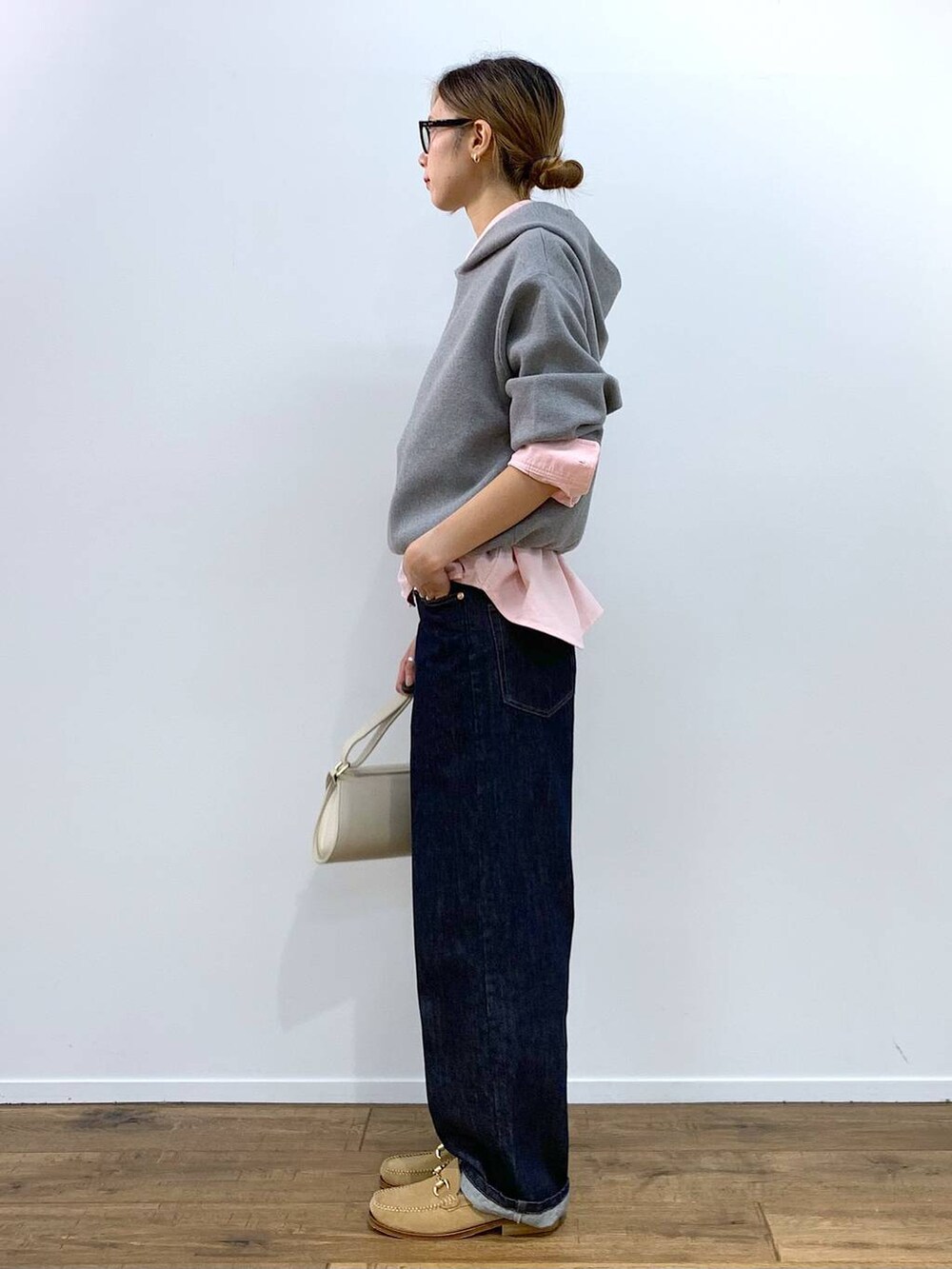 ホワイト系のショルダーバッグ、ピンク系のシャツ/ブラウス、ブルー系のデニムパンツを着用したレディースの秋コーディネートの3枚目の写真