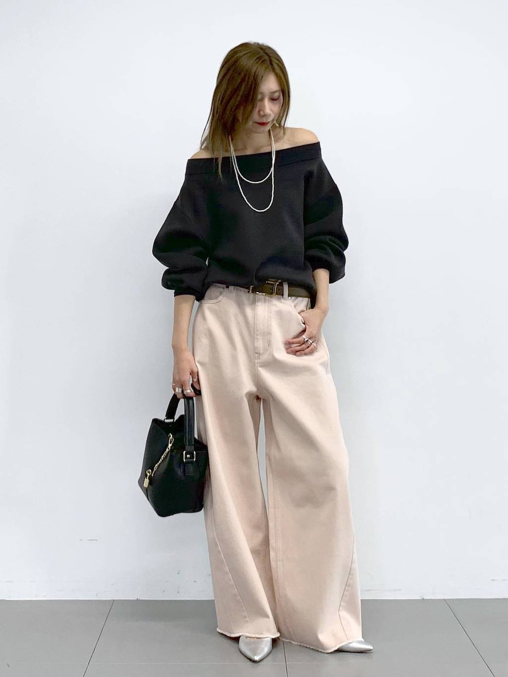 ピンク系のデニムパンツ、シルバー系のパンプス、グレー系のニット/セーターを着用したレディースの冬コーディネートの4枚目の写真