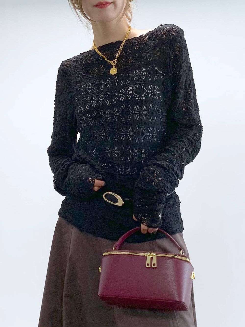 ブラック系のTシャツ/カットソー、ブラウン系のスカート、レッド系のハンドバッグを着用したレディースの冬コーディネートの7枚目の写真