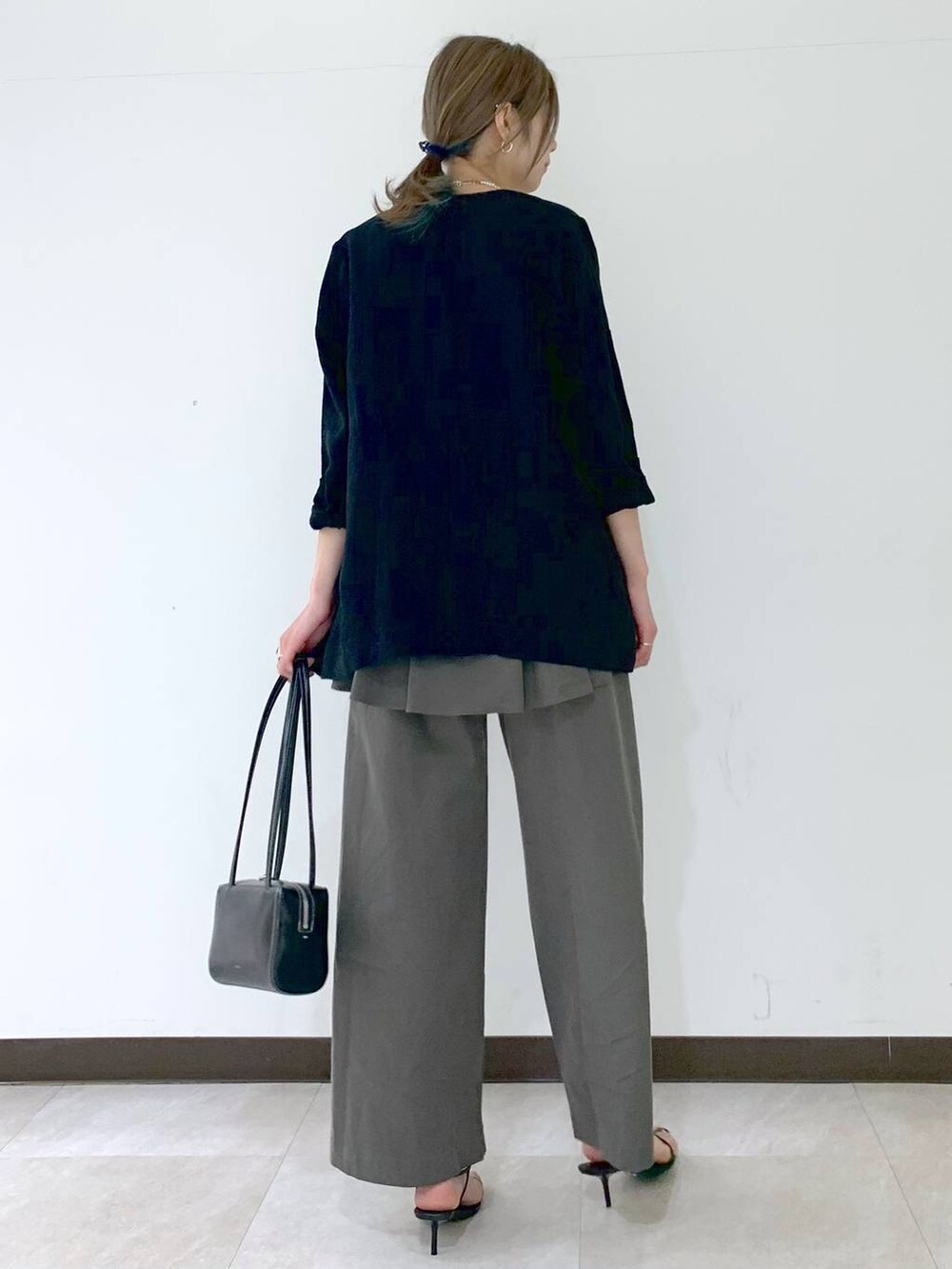ブラック系のノーカラージャケット、ブラック系のサンダル、グレー系のつなぎ/オールインワンを着用したレディースの春コーディネートの4枚目の写真
