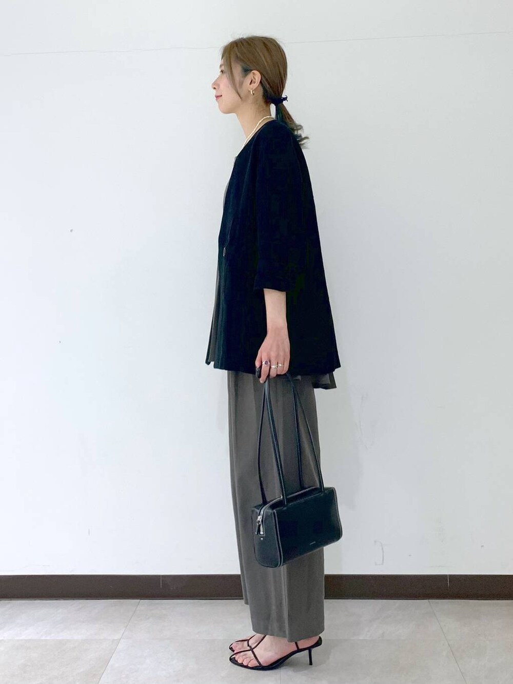 ブラック系のノーカラージャケット、ブラック系のサンダル、グレー系のつなぎ/オールインワンを着用したレディースの春コーディネートの3枚目の写真