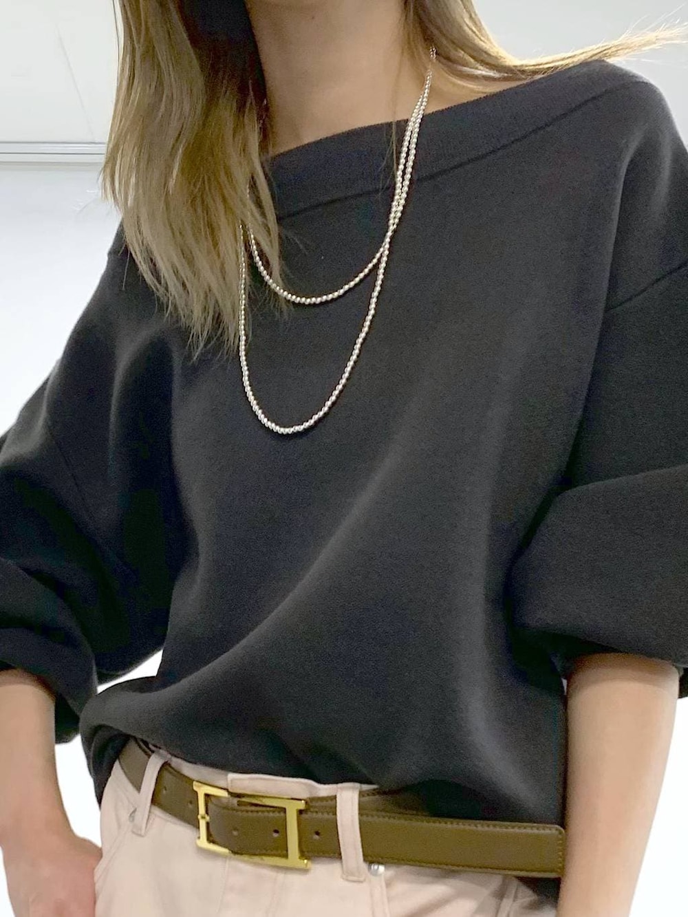 ピンク系のデニムパンツ、シルバー系のパンプス、グレー系のニット/セーターを着用したレディースの冬コーディネートの7枚目の写真