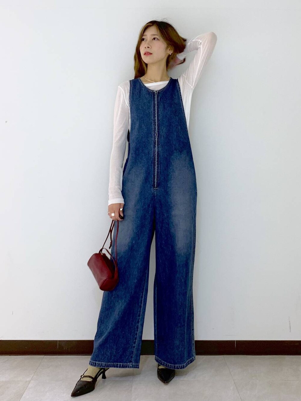 レッド系のショルダーバッグ、ホワイト系のTシャツ/カットソー、ブラウン系のソックス/靴下を着用したレディースの秋コーディネートの2枚目の写真