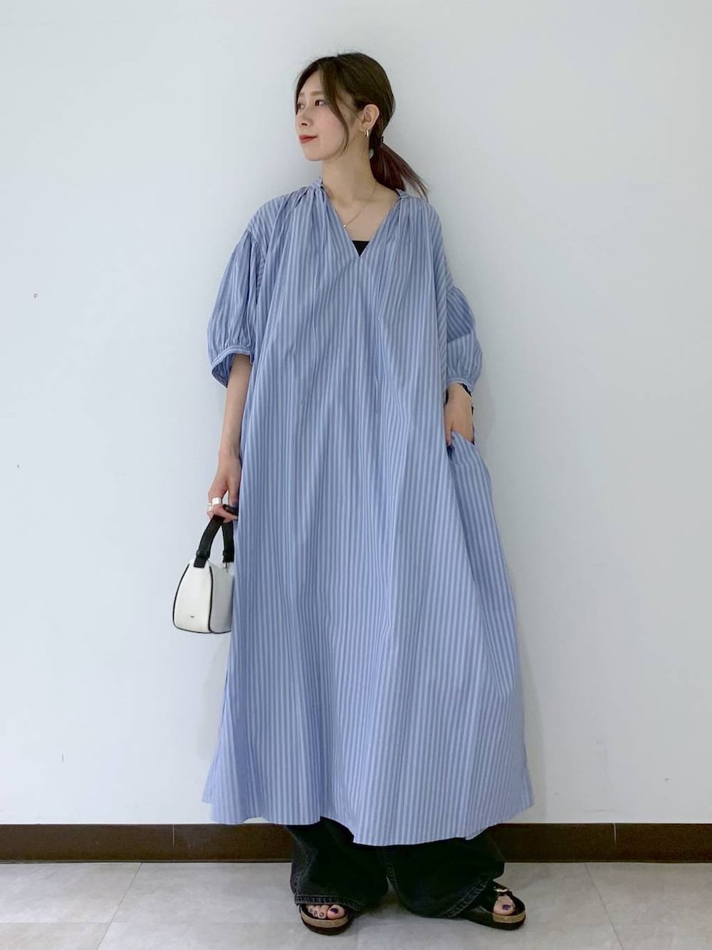 ブラック系のサンダル、ブラック系のデニムパンツ、ブルー系のワンピースを着用したレディースの夏コーディネートの6枚目の写真