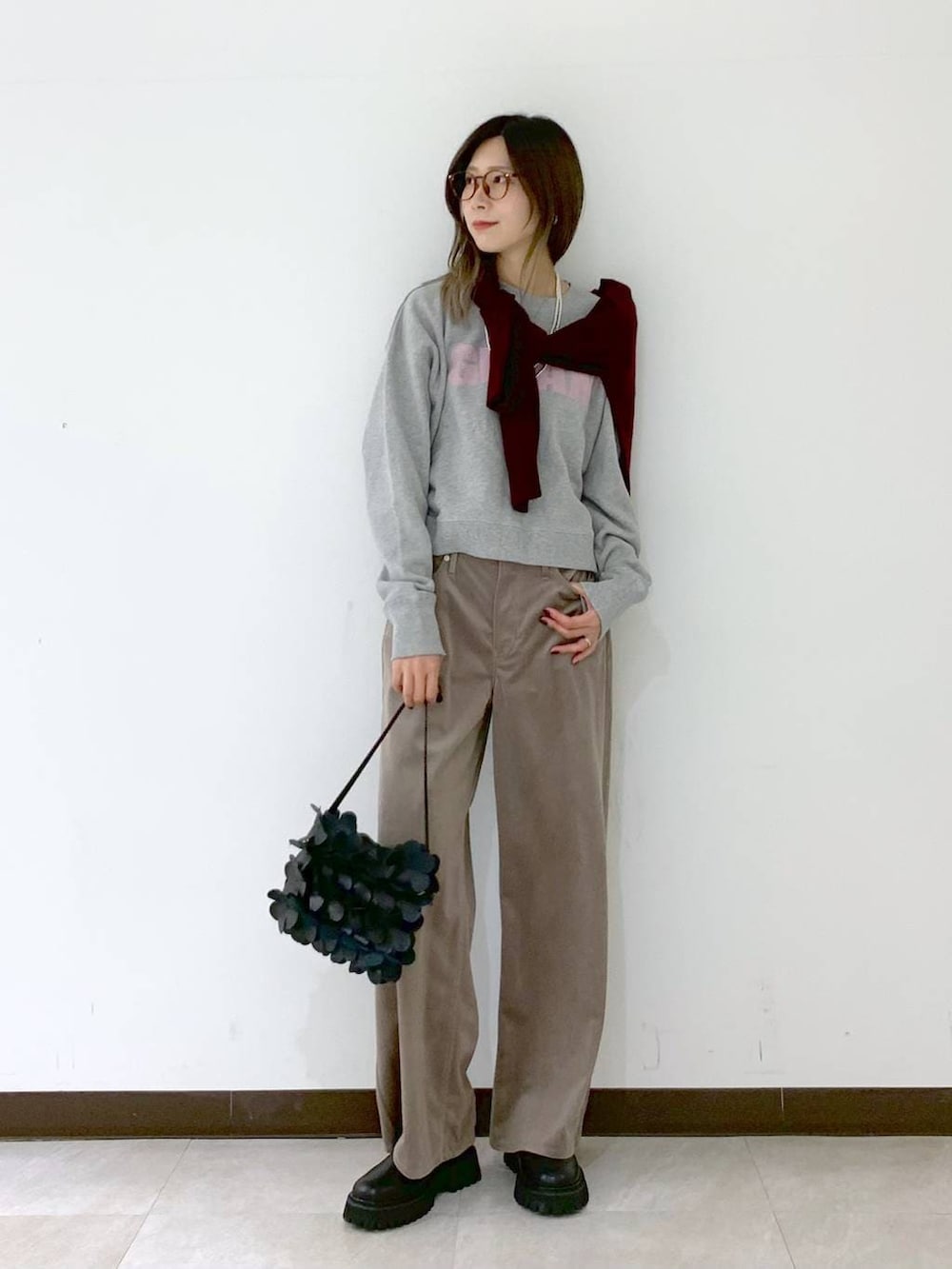 レッド系のカーディガン/ボレロ、ブラック系のショルダーバッグ、ブラック系のサンダルを着用したレディースの冬コーディネートの7枚目の写真