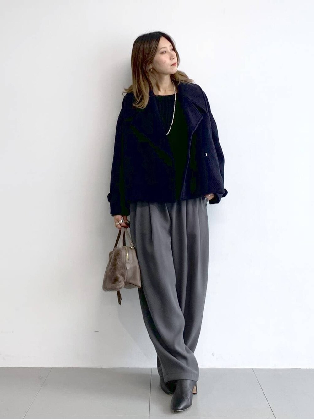 グレー系のその他パンツ、ブラック系のブーツ、ブラウン系のハンドバッグを着用したレディースの冬コーディネートの7枚目の写真