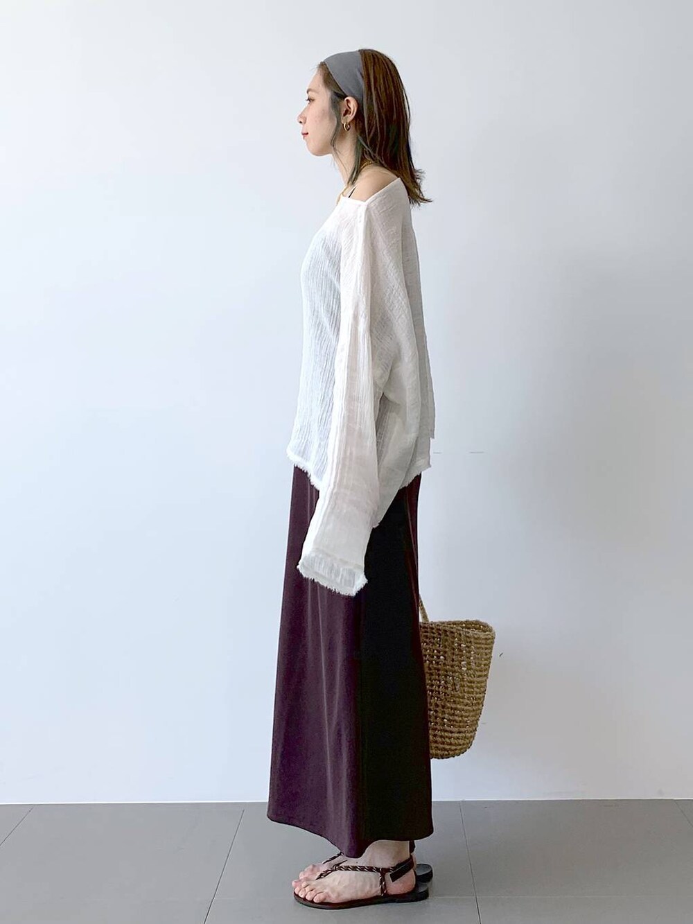 ベージュ系のかごバッグ、ブラウン系のサンダル、ブラウン系のワンピースを着用したレディースの夏コーディネートの4枚目の写真