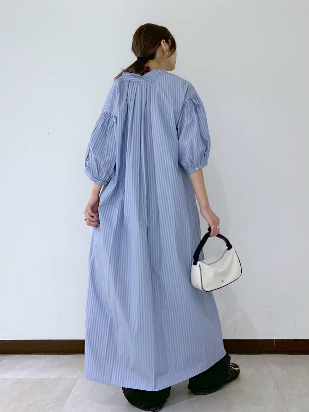 ブラック系のサンダル、ブラック系のデニムパンツ、ブルー系のワンピースを着用したレディースの夏コーディネートの4枚目の写真